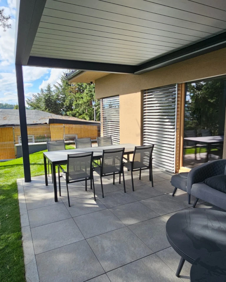 Nowoczesna pergola bioklimatyczna z ogrodową częścią wypoczynkową na tarasie domu jednorodzinnego