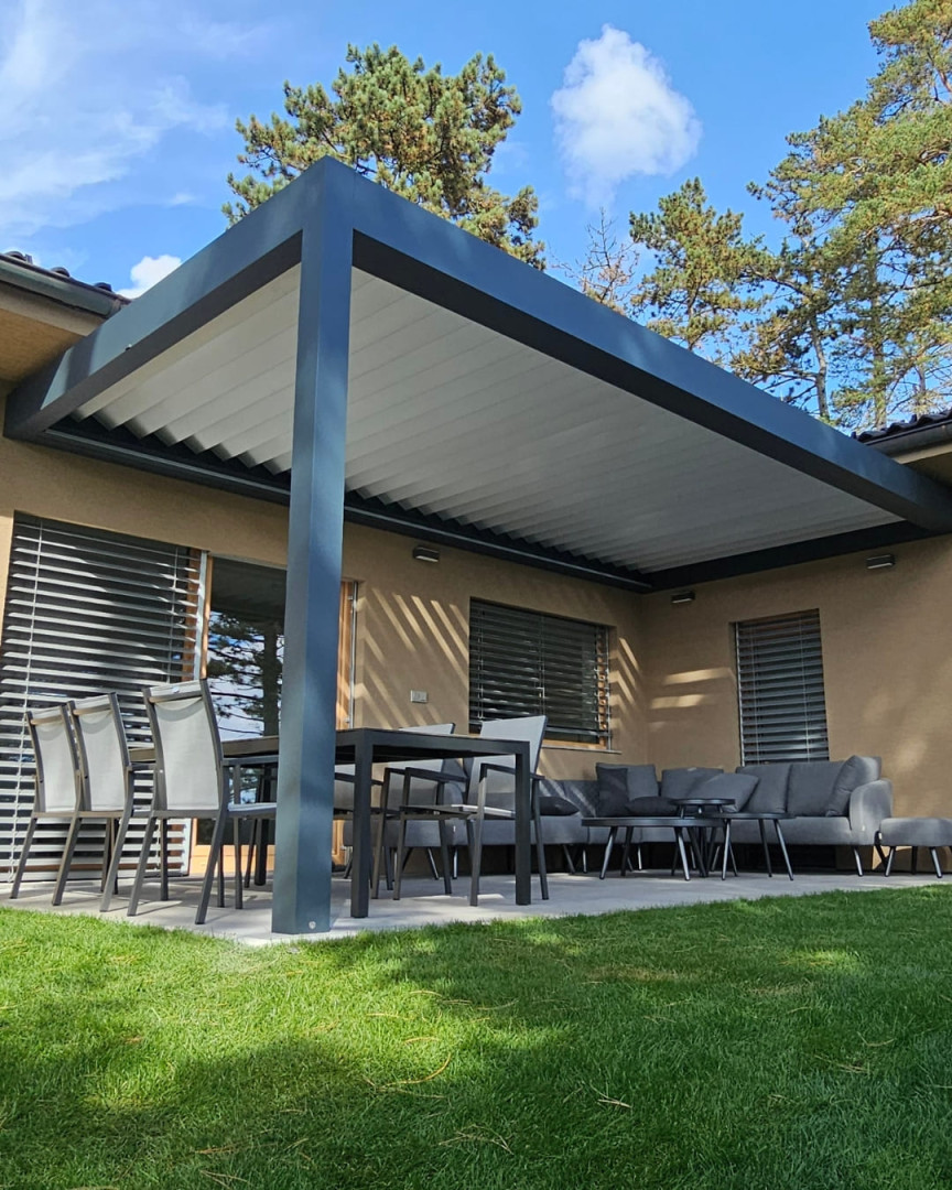 Nowoczesna pergola bioklimatyczna z aluminiową konstrukcją i regulowanymi lamelami na tarasie domu jednorodzinnego