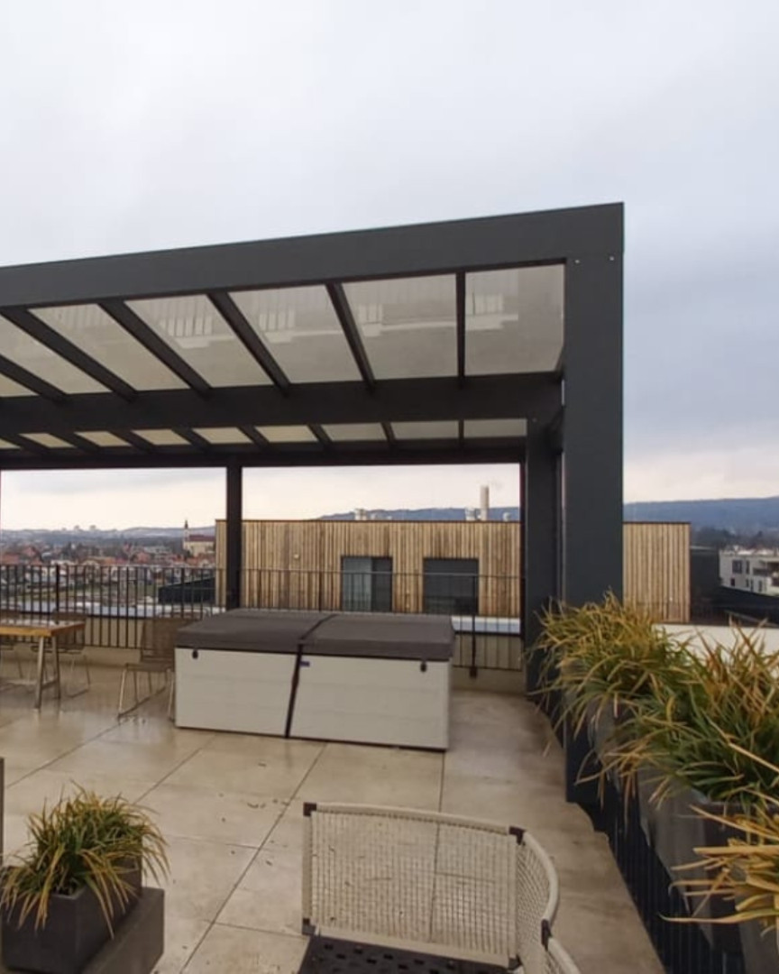 Nowoczesna pergola aluminiowa na tarasie dachowym z widokiem na miasto i jacuzzi