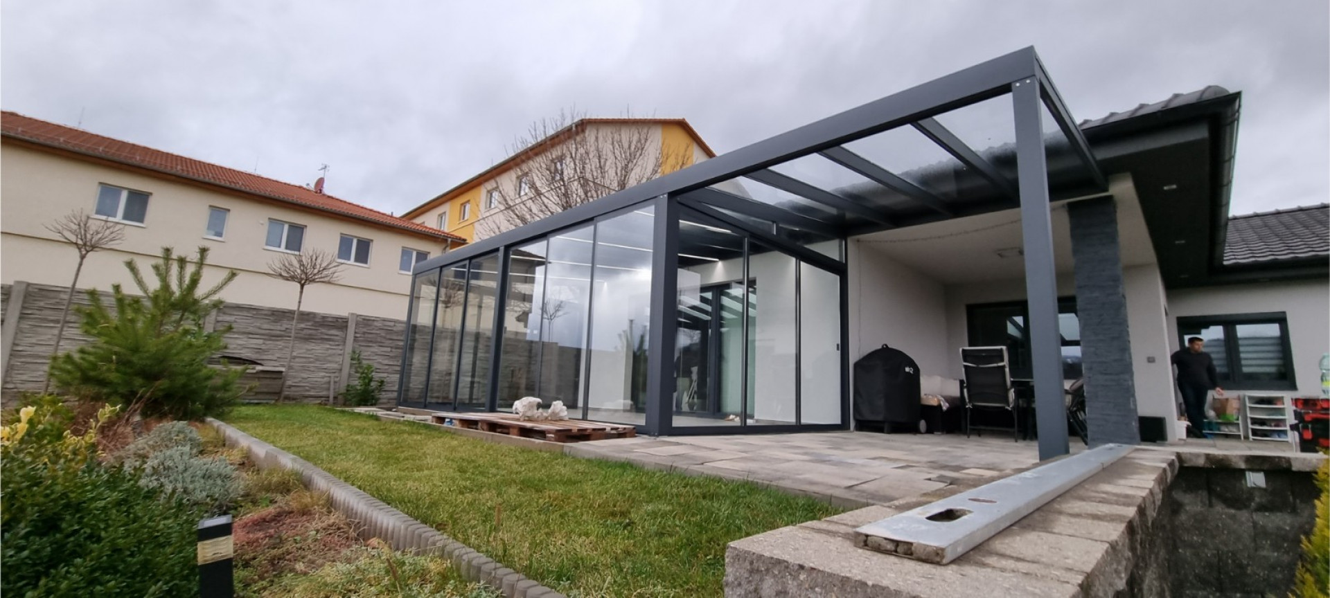 Nowoczesna, przeszklona pergola z aluminium o antracytowej konstrukcji, wzniesiona przy domu jednorodzinnym w Kláštercu.