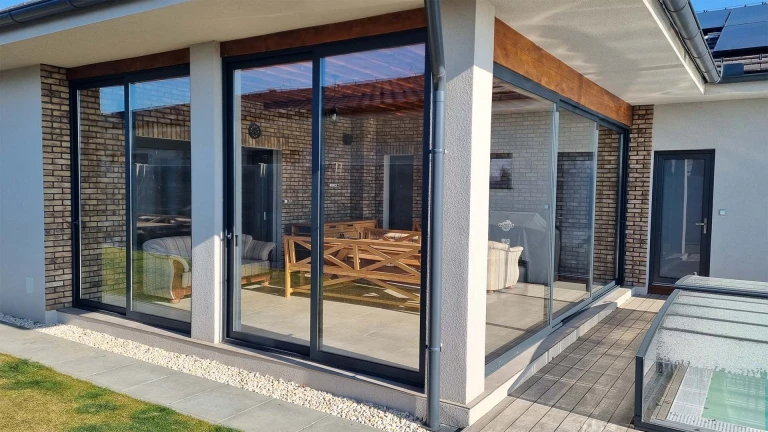 Nowoczesne aluminiowe przeszklenie tarasu z drzwiami przesuwnymi w domu jednorodzinnym