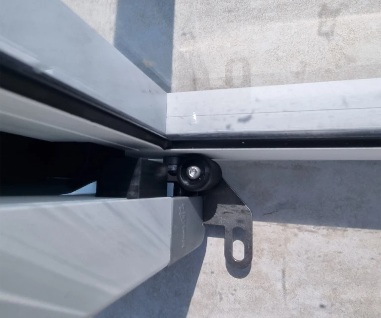 Szczegółowe ujęcie mechanizmu prowadzącego i kółka bezszynowego zadaszenia basenu